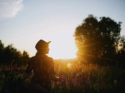 Silhouette of woman relaxing in lupine field